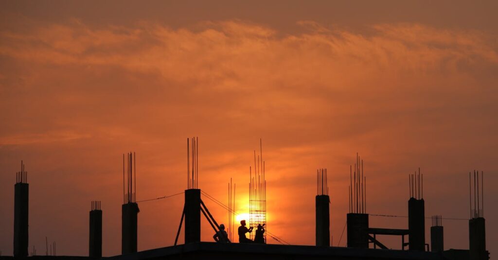 pexels-photo-176342-176342 Silhouette of workers on a construction site against a vibrant sunset sky.